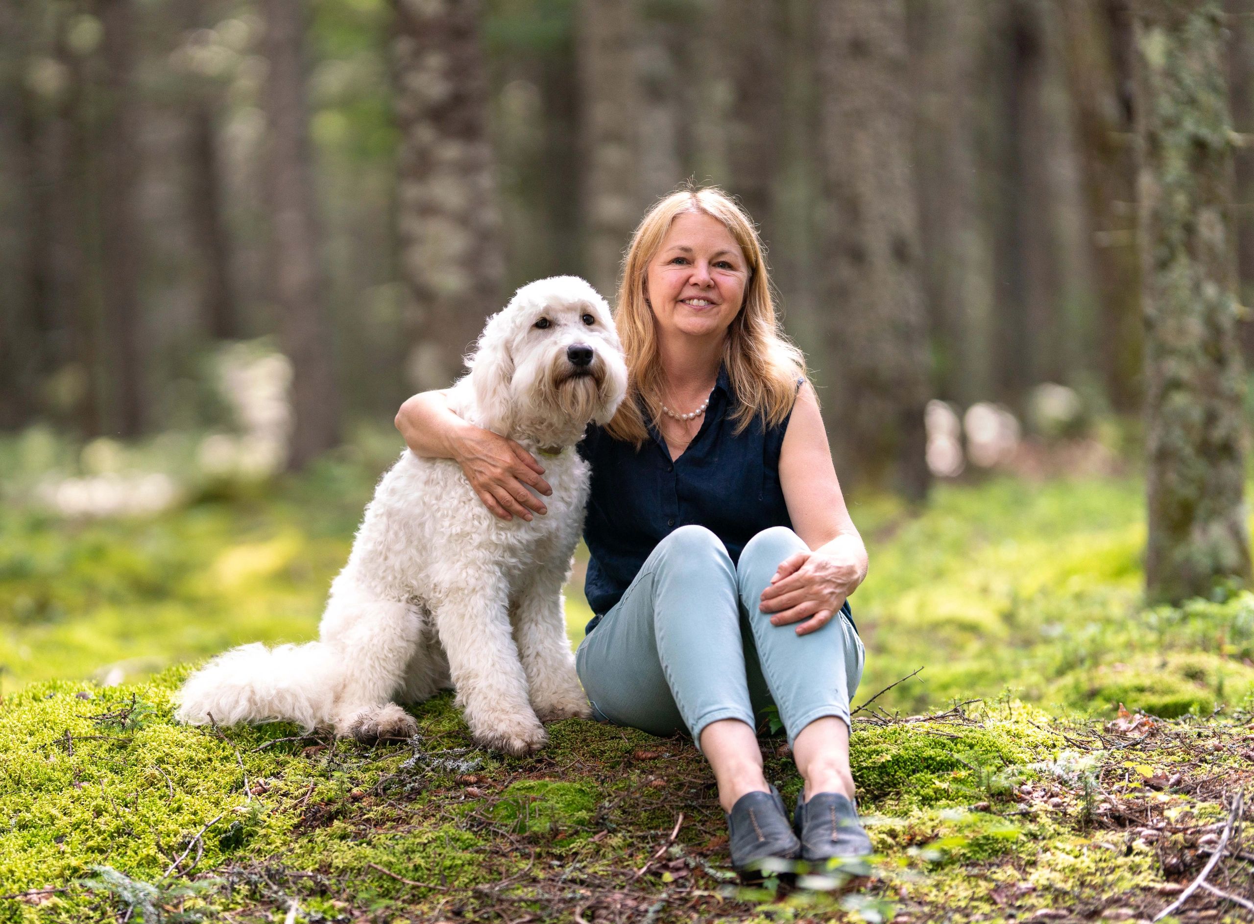 Megan with her Goldendoodle in a Maine forest